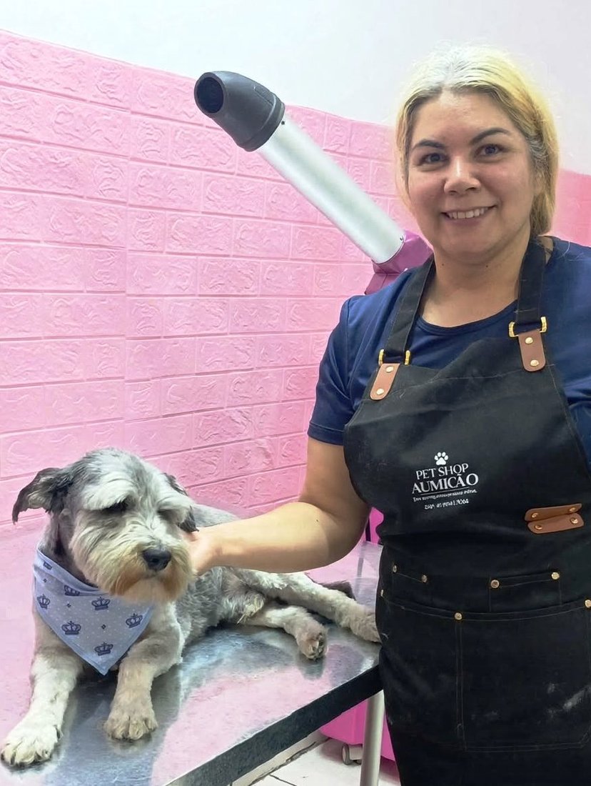 Schnauzer com bandana azul ao lado da equipe Aumicão